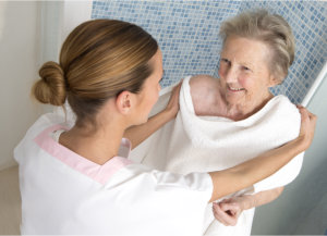 caregiver assisting and elderly woman in bathing